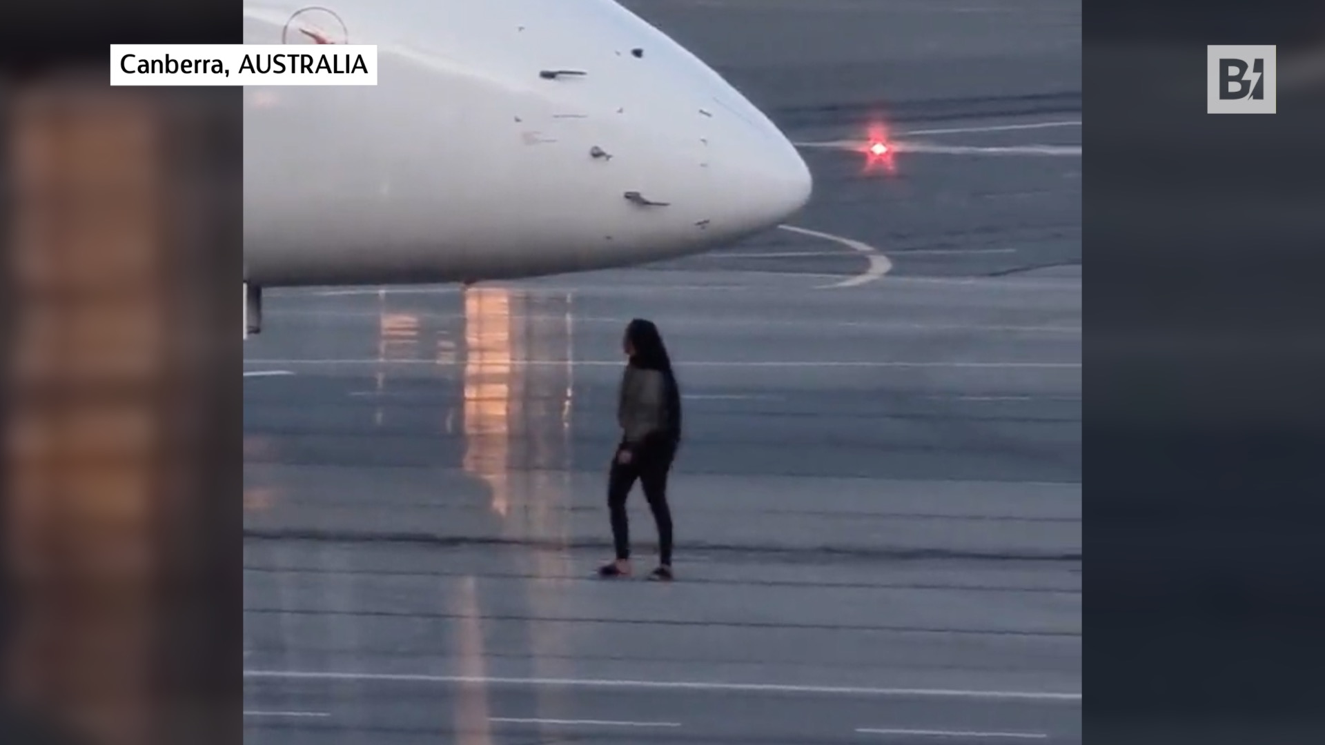 Mujer parada frente a un avión que…