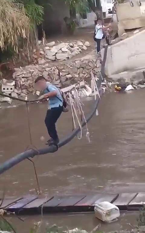 Niños haciendo equilibrios sobre una cuerda para cruzar un río lleno de cocodrilos e ir al colegio