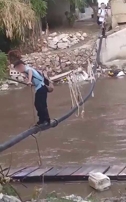 Niños haciendo equilibrios sobre una cuerda para cruzar un río lleno de cocodrilos e ir al colegio