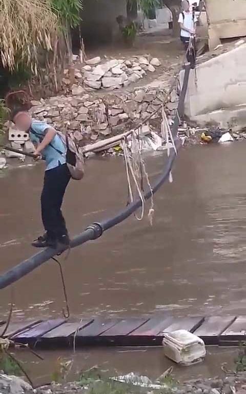 Niños haciendo equilibrios sobre una cuerda para cruzar un río lleno de cocodrilos e ir al colegio