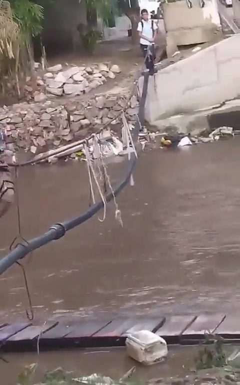 Niños haciendo equilibrios sobre una cuerda para cruzar un río lleno de cocodrilos e ir al colegio