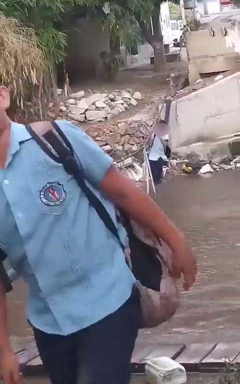 Niños haciendo equilibrios sobre una cuerda para cruzar un río lleno de cocodrilos e ir al colegio