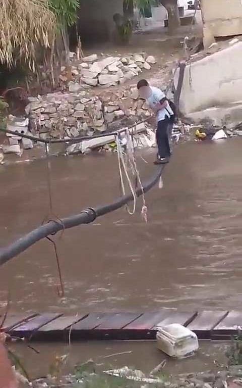 Niños haciendo equilibrios sobre una cuerda para cruzar un río lleno de cocodrilos e ir al colegio