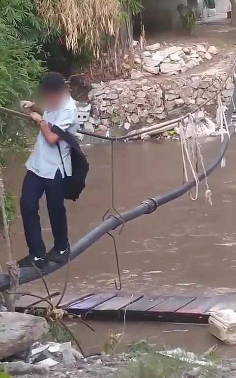 Niños haciendo equilibrios sobre una cuerda para cruzar un río lleno de cocodrilos e ir al colegio